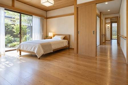 庭に面した1階の寝室にベッドを置き、引き戸の先の手すり付き廊下へつながる配置。